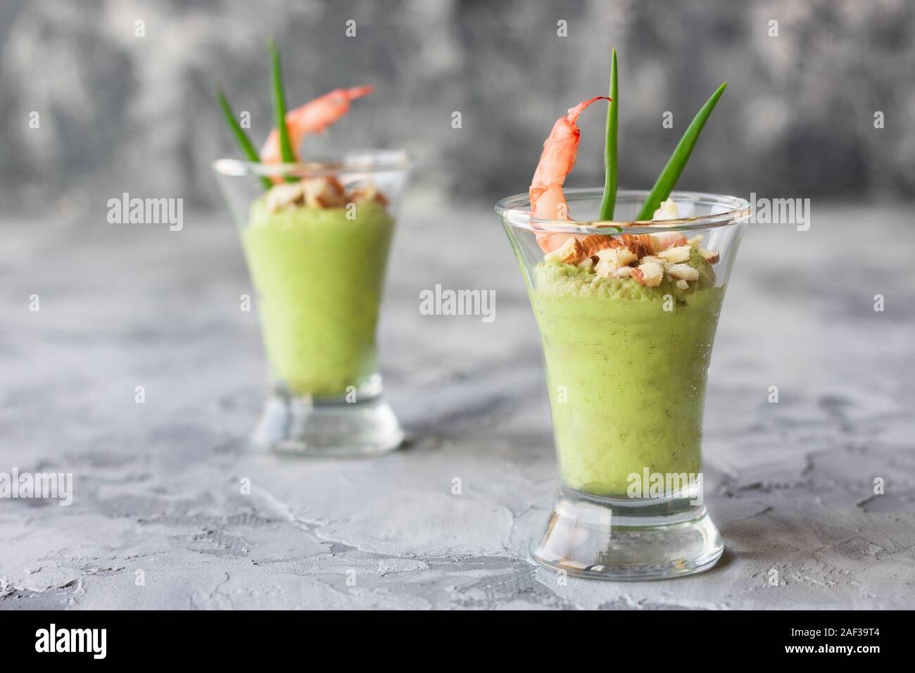 Avocado- und grüner Apfel Mousse mit Garnelen und Mandeln. Teil Vorspeise für ein Buffet oder Bankett in ein Glas. Stockfoto