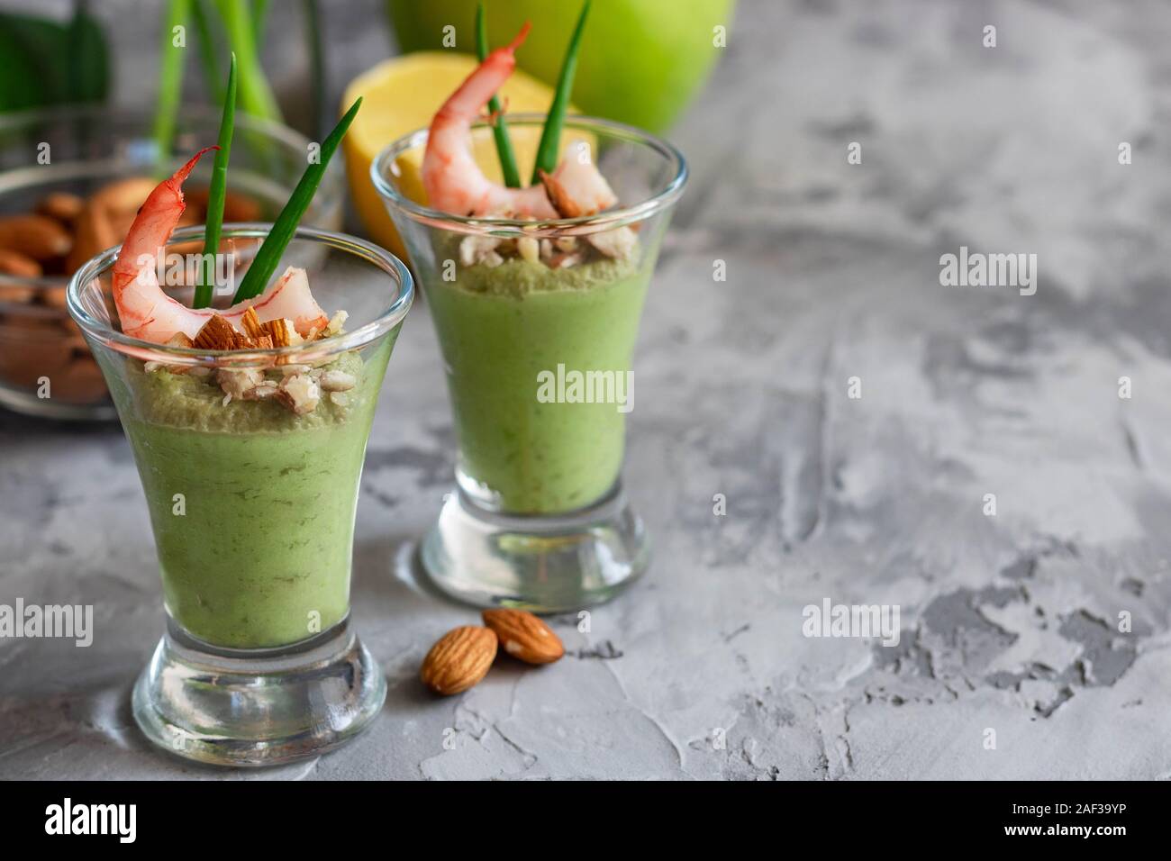 Avocado- und grüner Apfel Mousse mit Garnelen und Mandeln. Teil Vorspeise für ein Buffet oder Bankett in ein Glas. Stockfoto