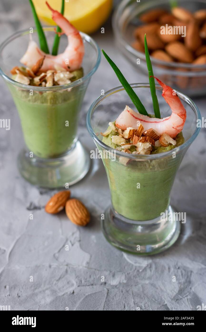 Avocado- und grüner Apfel Mousse mit Garnelen und Mandeln. Teil Vorspeise für ein Buffet oder Bankett in ein Glas. Stockfoto