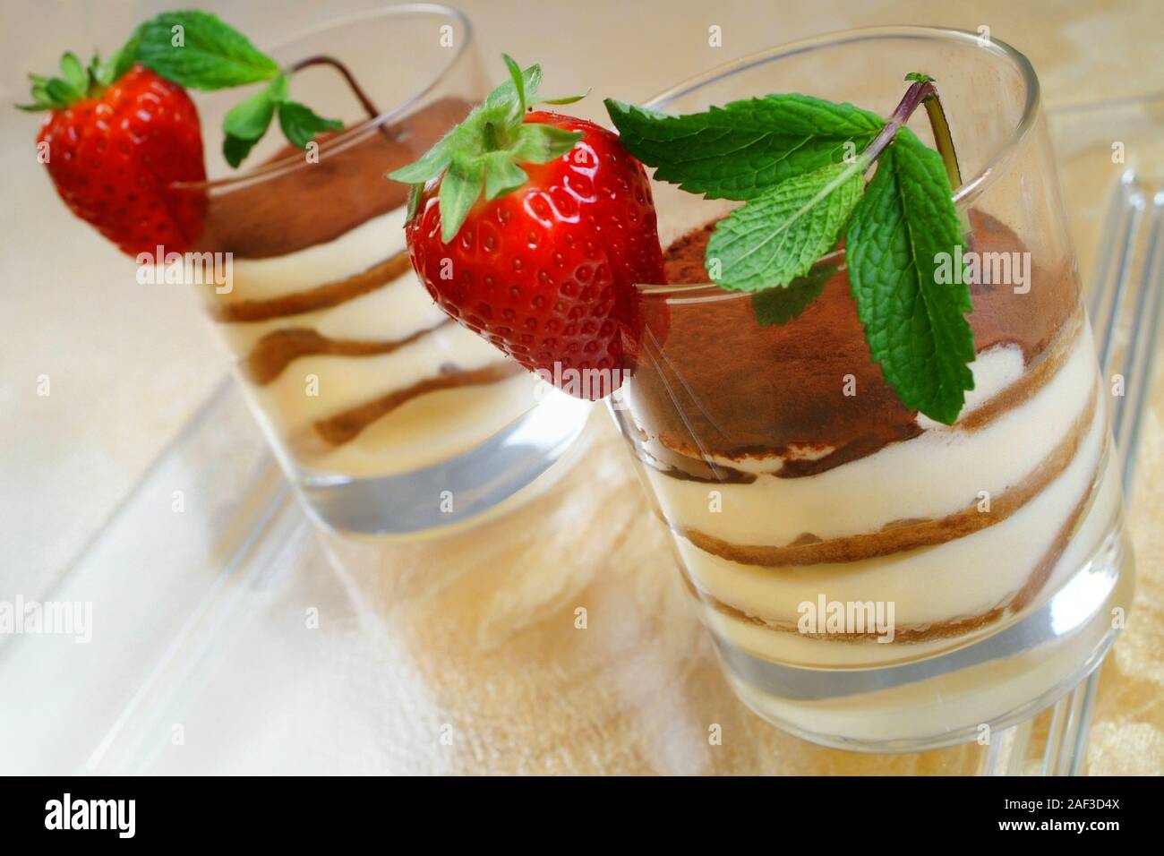 Italienisches Essen Rezept Tiramisù. Typische italienische Dessert in  Gläsern mit Schichten von Mascarpone, Plätzchen, Kaffee und Minze Erdbeeren  Stockfotografie - Alamy
