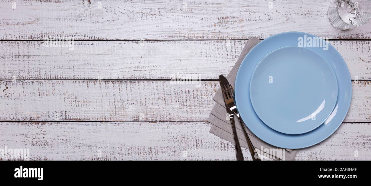 Blue Platten, Servietten und Besteck auf einer alten weißen Holz- Hintergrund. Blick von oben. Stockfoto