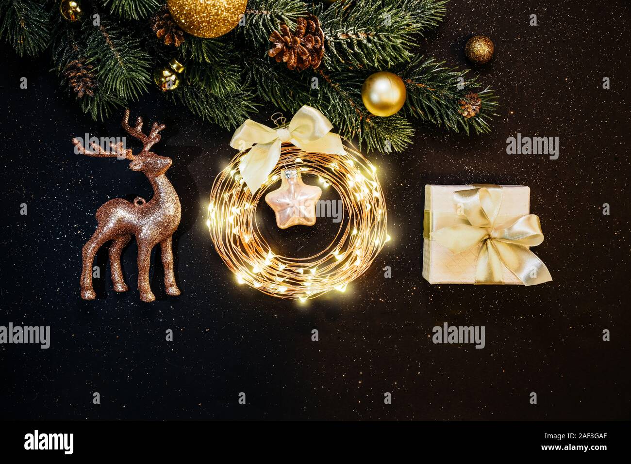 Weihnachtsbaum, Gold Dekorationen, Rentier, Garland, Geschenk auf dunklem Hintergrund: Stockfoto