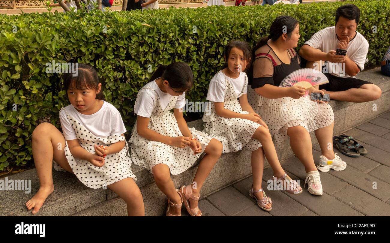 Chinesischen Familie mit Mädchen und Mutter in die passende Polka Dot Kleider entspannende außerhalb der Verbotenen Stadt, Peking, China Stockfoto