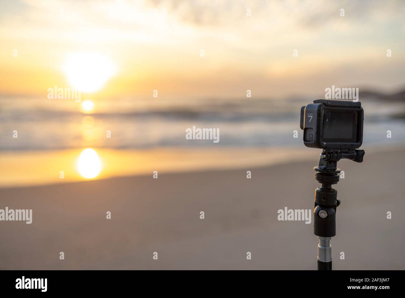 GoPro Hero 7 auf einem Stativ auf einem Strand in Rio taping und den  Sonnenaufgang mit der Sonne im Meer Wasser widerspiegeln Stockfotografie -  Alamy