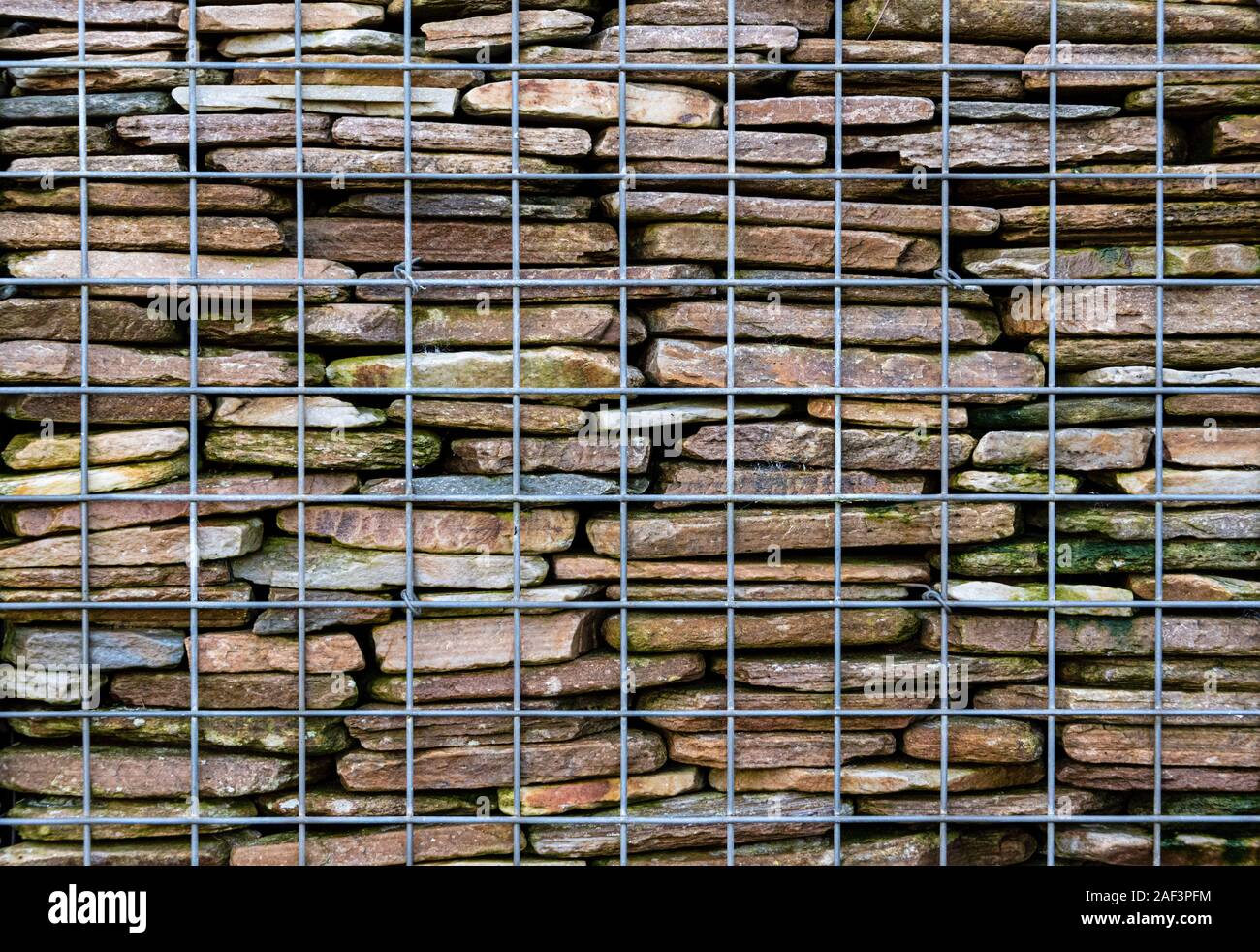 Nahaufnahme von gabionen Stützmauer, gebaut von einem Draht Käfig und Stein innen gestapelt. Stockfoto