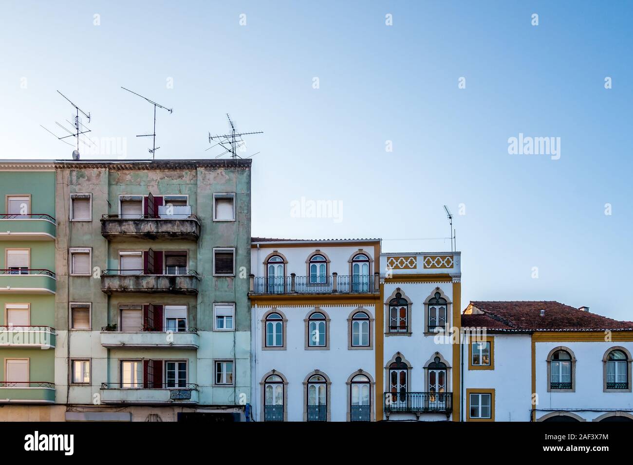 Zeile 5 verschiedene Gebäude, Fassaden mit constrasting Architektur und Farben im Profil gegen den blauen Himmel Hintergrund in Tomar Portugal Stockfoto