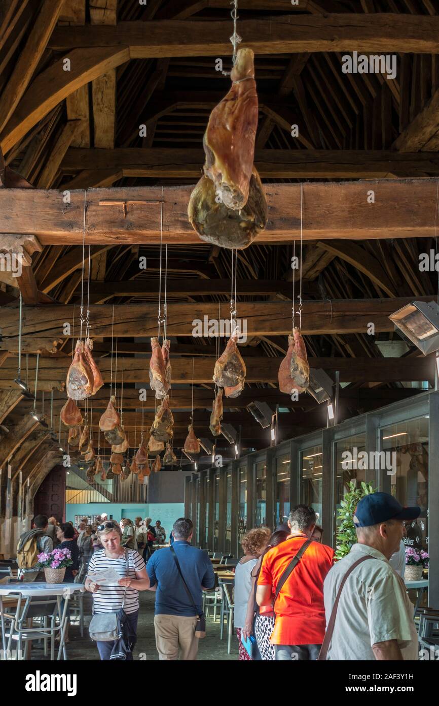 Touristen, die in der Groot Vleeshuis/grosse Metzgerei mit Schinken von der Decke in der Stadt Gent/Gent, Ostflandern, Belgien hängen Stockfoto