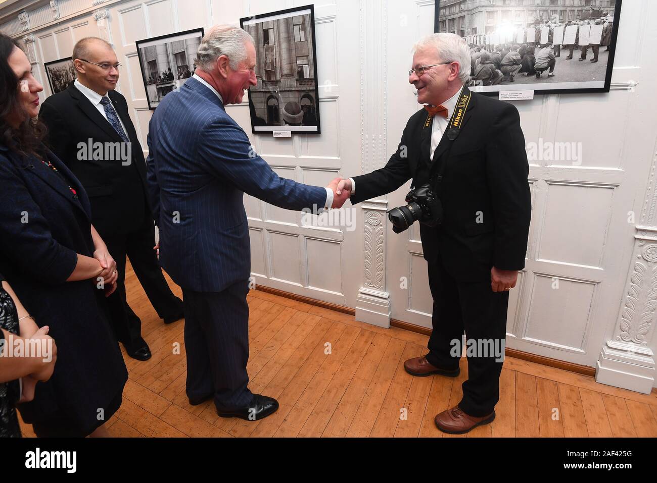 Der Prinz von Wales treffen Rumänischen Fotografen Sorim Lupfa bei einem Besuch der Rumänischen Kulturinstitut, Central London, wo er offiziell eine Ausstellung 30 Jahre seit der Rumänischen Revolution eröffnet. Stockfoto