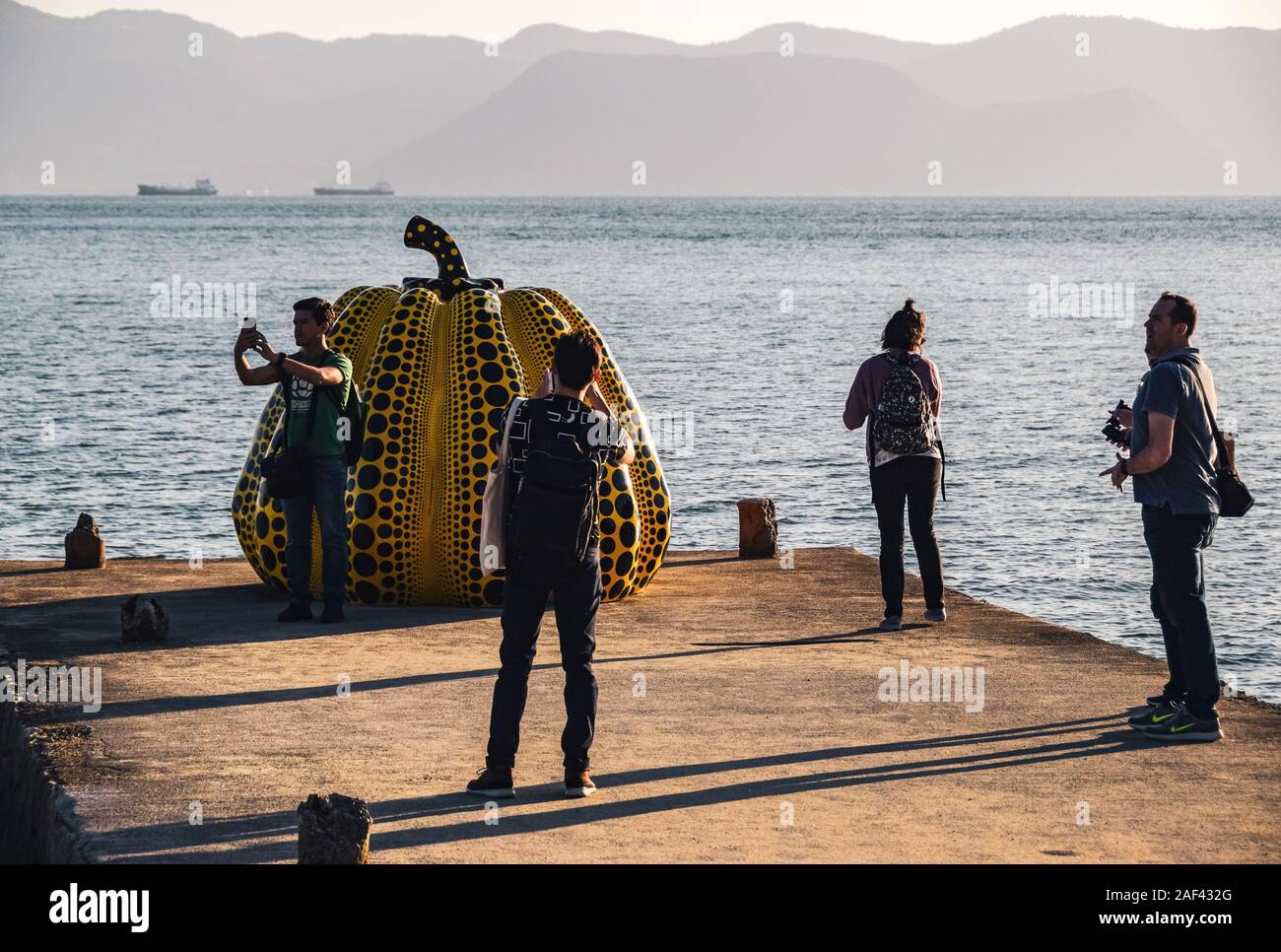Touristen Aufnehmen von Fotos mit Yayoi Kusama Giant's gelber Kürbis Skulptur in Naoshima, Japan. Stockfoto