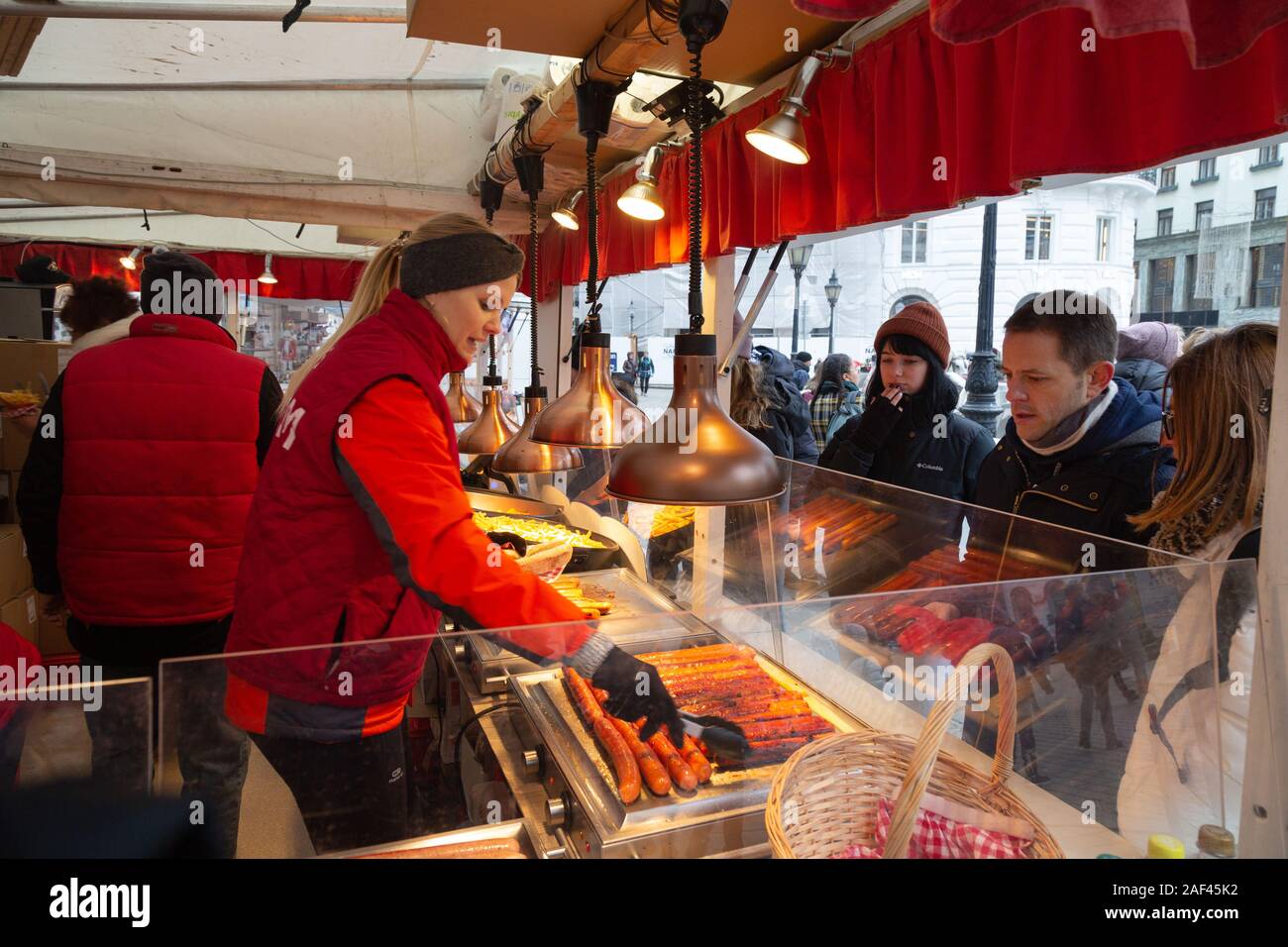 Wiener Weihnachtsmarkt; Menschen kaufen Wurst an einer Garküche, Hofburg Weihnachtsmärkte, Wien Österreich Europa Stockfoto