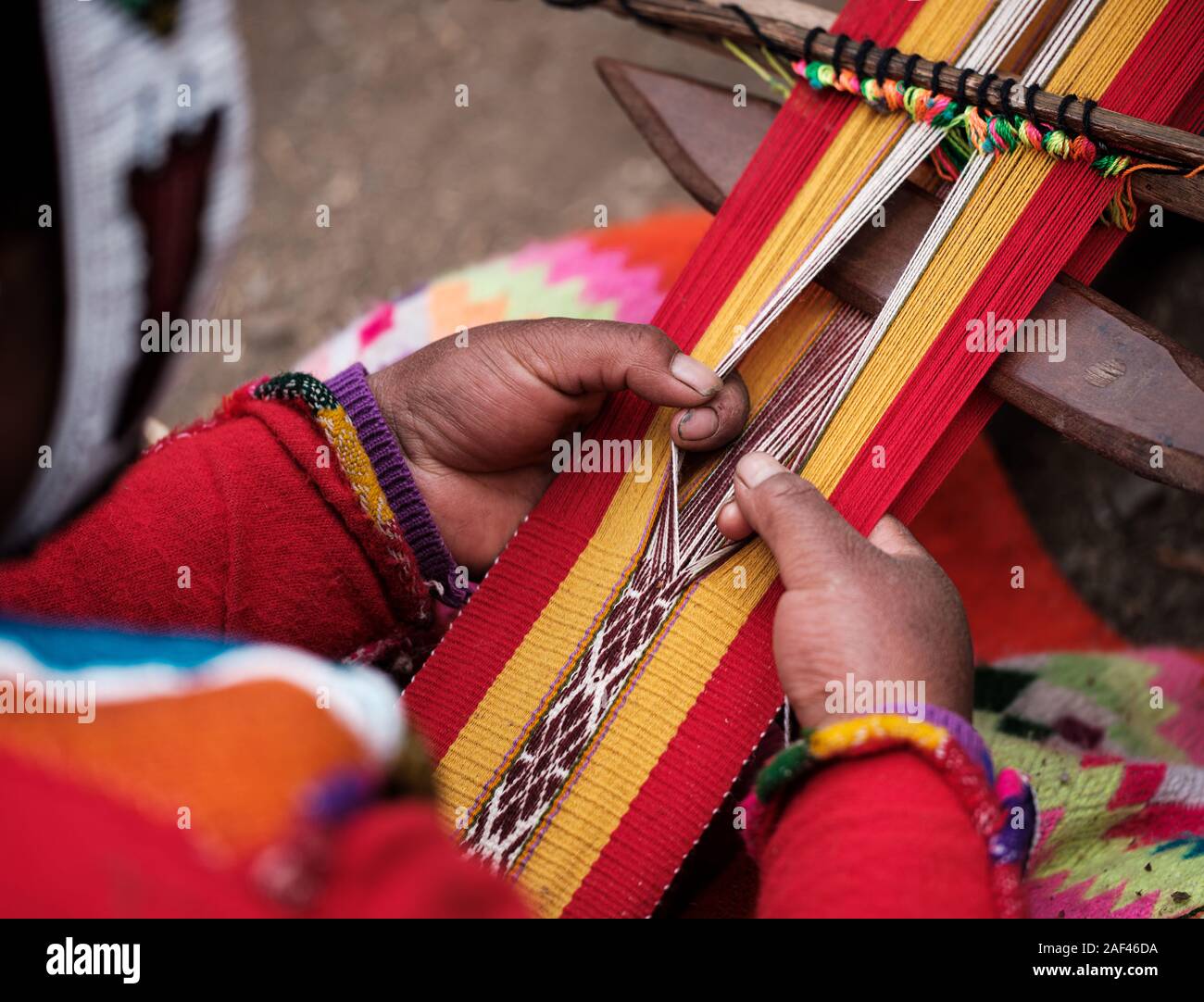 CUSCO, PERU - ca. September 2019: Hände eines peruanischen Frau Weberei in der Region das Heilige Tal der Inkas in Peru/ Stockfoto