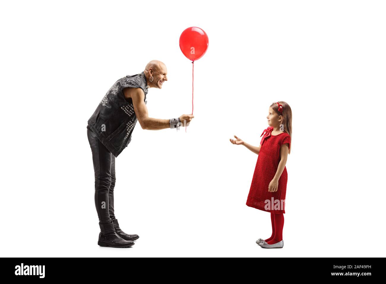 Volle Länge Profil Schuß eines Rock Star mit einem roten Ballon zu einem kleinen Mädchen auf weißem Hintergrund Stockfoto