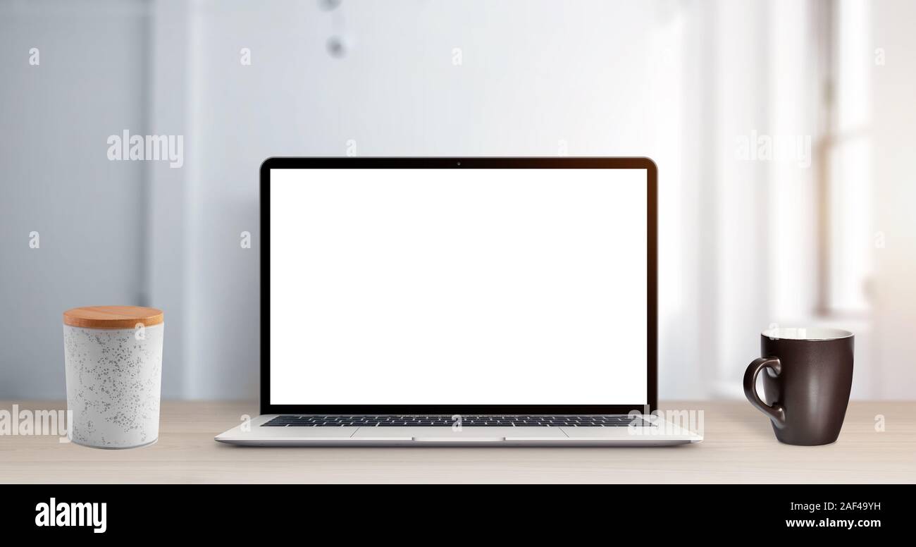 Laptop mockup auf Büro Schreibtisch. Isolierte Bildschirm für ap oder Web site Förderung. Clean desk mit Box und Tasse Kaffee Stockfoto