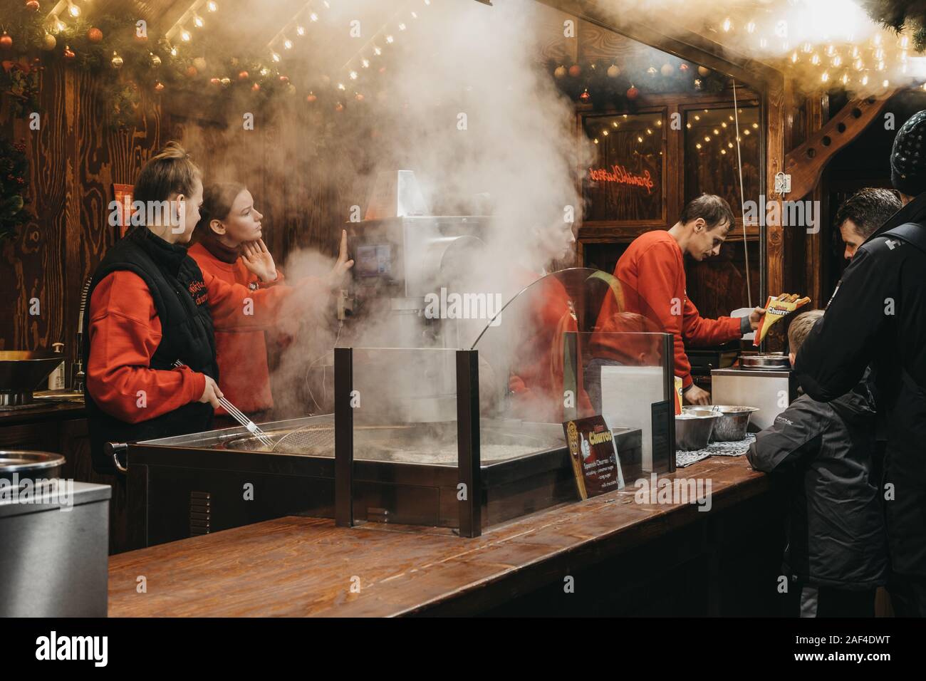 London, Großbritannien - 24 November, 2019: Leute arbeiten bei Churros auf dem Weihnachtsmarkt auf dem Trafalgar Square in London. Churros sind eine traditionelle Snack aus Stockfoto