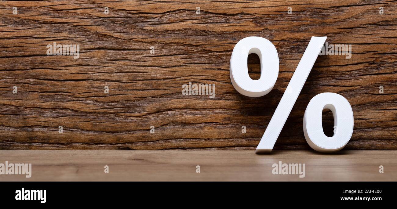 3D-weißen Prozentzeichen gegen die Holzwand Stockfoto