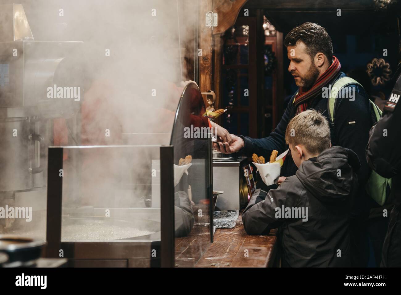 London, Großbritannien - 24 November, 2019: die Menschen kaufen Churros aus einer auf dem Weihnachtsmarkt auf dem Trafalgar Square in London. Churros sind eine traditionelle Snack fr Stockfoto
