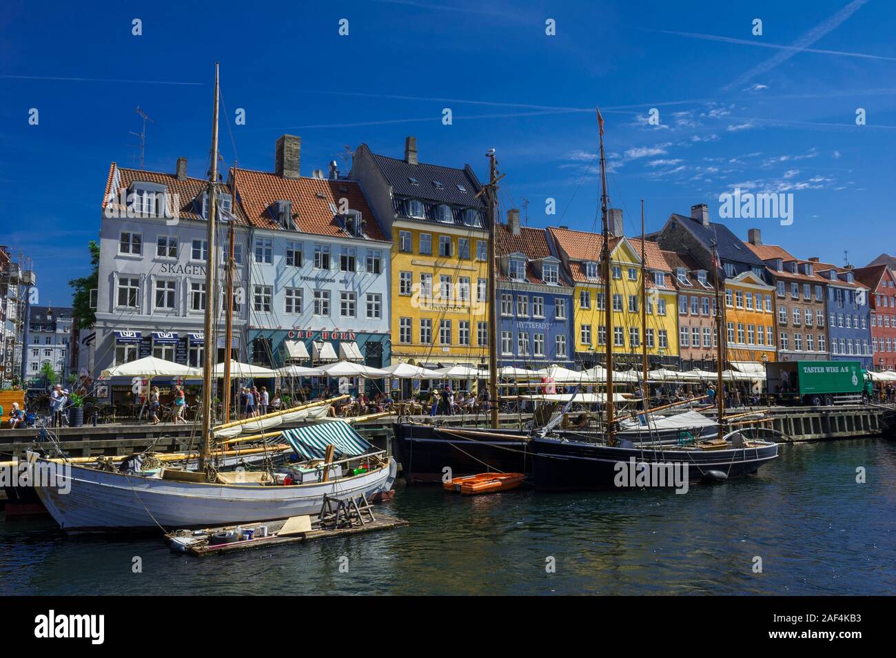 Kleine Segelboote auf dem Nyhavn Kanal vor hellen Gebäude in Kopenhagen, Dänemark Stockfoto