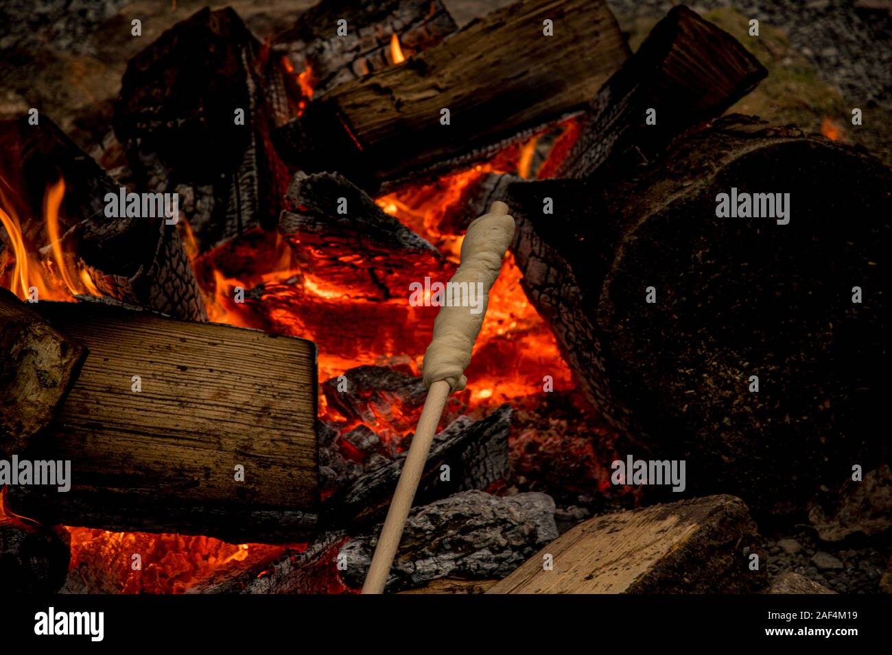 Vorbereitung stick Brot in der Glut eines Lagerfeuers Stockfoto