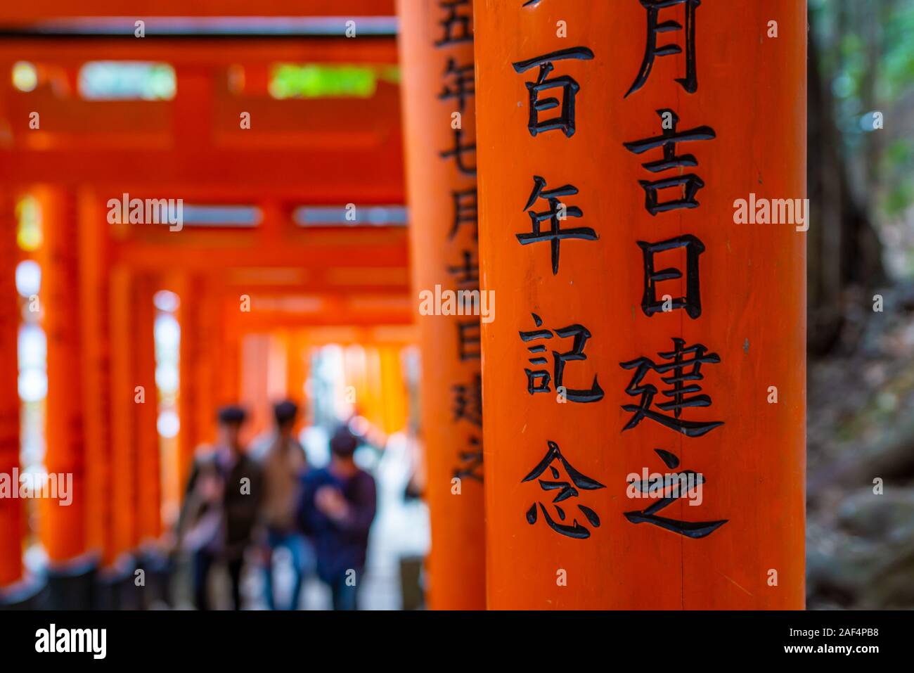 Kyoto, Japan - 24. März 2017: unkenntlich Menschen gehen unter tori Tore und in der Nähe der Japanischen Schrift am Fushimi Inari Schrein, auf Stockfoto