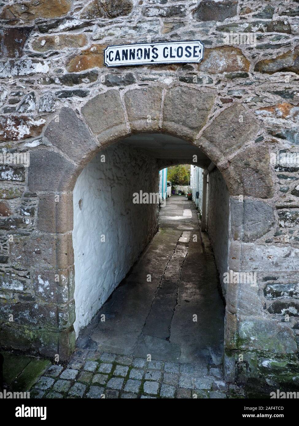 Weiße Gasse von der Straße mit Vorzeichen Kanonen Schließen oben gewölbte Eingang in Kirkcudbright, Dumfries and Galloway, Schottland, Großbritannien Stockfoto