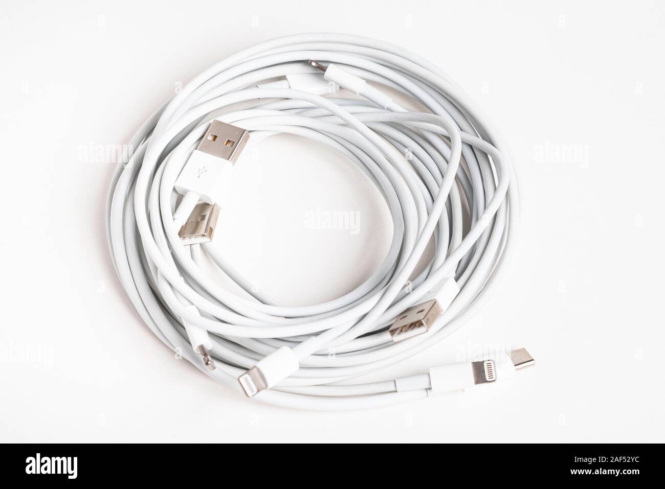 Vidalia, Georgia/USA, 8. September 2019: Mehrere weiße Apple Power Kabel und Anschlüsse in einem organisierten Swirl auf weißem Hintergrund. Stockfoto