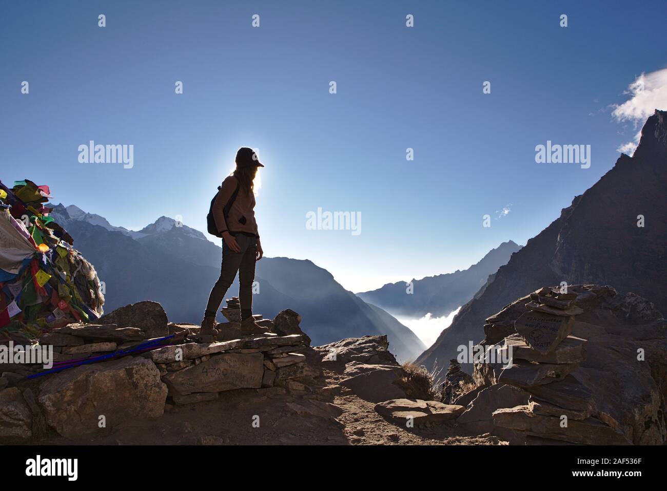 Silhouette der westlichen Frau, die auf einem Berg in Nepal mit klaren blauen Himmel Stockfoto