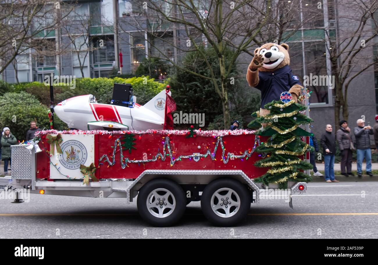 Vancouver, Kanada - 1. Dezember 2019: Während der jährlichen Weihnachts-Parade in Vancouver winkt ein Darsteller in einem Bärenkostüm Menschen von der Plattform Stockfoto