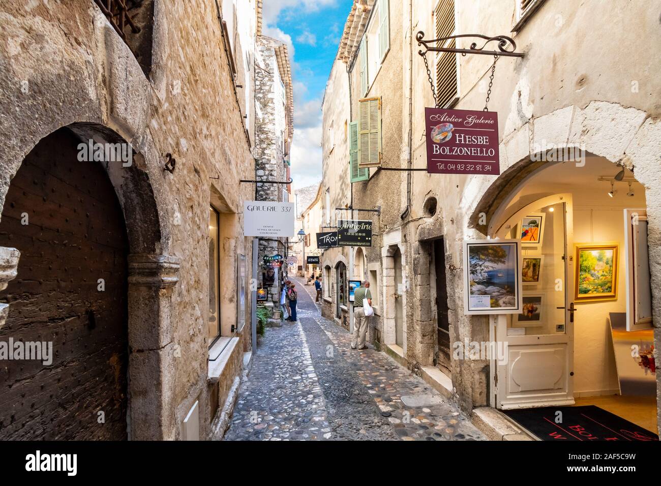 Geschäfte und Galerien säumen die engen, kopfsteingepflasterten Straßen im mittelalterlichen Dorf St Paul de Vance an der Französischen Riviera. Stockfoto