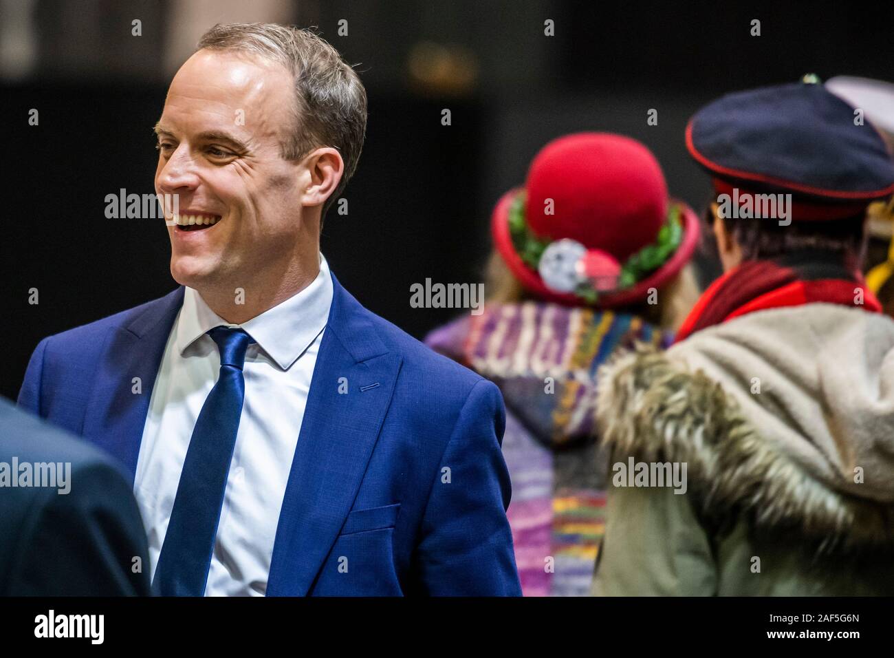 Esher, London, UK. 13 Dez, 2019. Dominic Raab Ansichten der Graf mit seinen Mitarbeitern und der offiziellen Monster Raving Loony Party im Hintergrund - Der Graf und Ergebnis am Esher und Walton Wahlkreis im 2019 allgemeine Wahlen. Wo Dominic Raab ist der etablierte Konservative und wird gejagt von Monica Harding für die Lib Dems. Credit: Guy Bell/Alamy leben Nachrichten Stockfoto