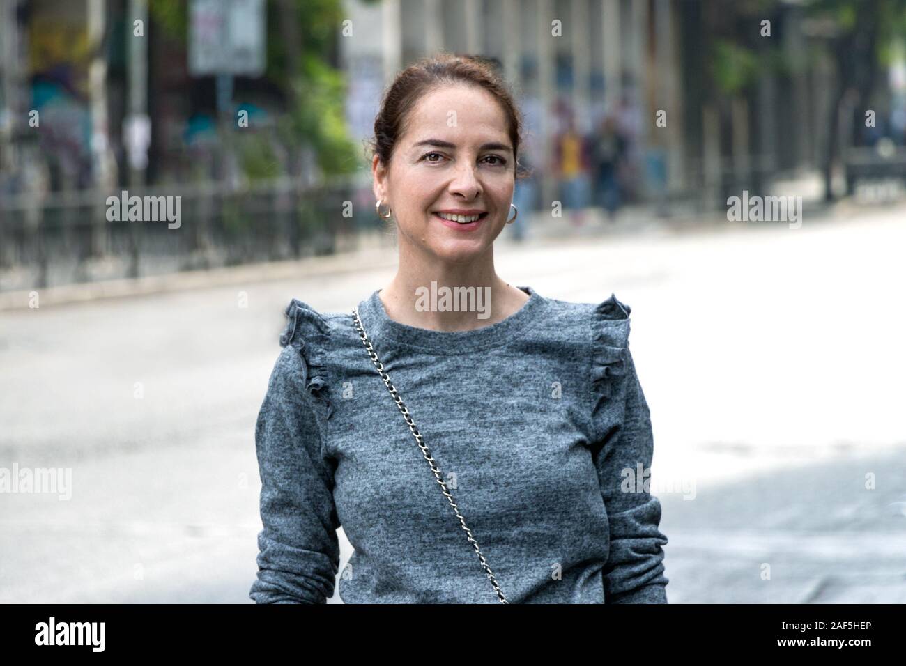 Porträt einer reifen Frau von 45 - 50 Jahren lächelnd suchen Kamera über eine städtische - Stadt Hintergrund Stockfoto