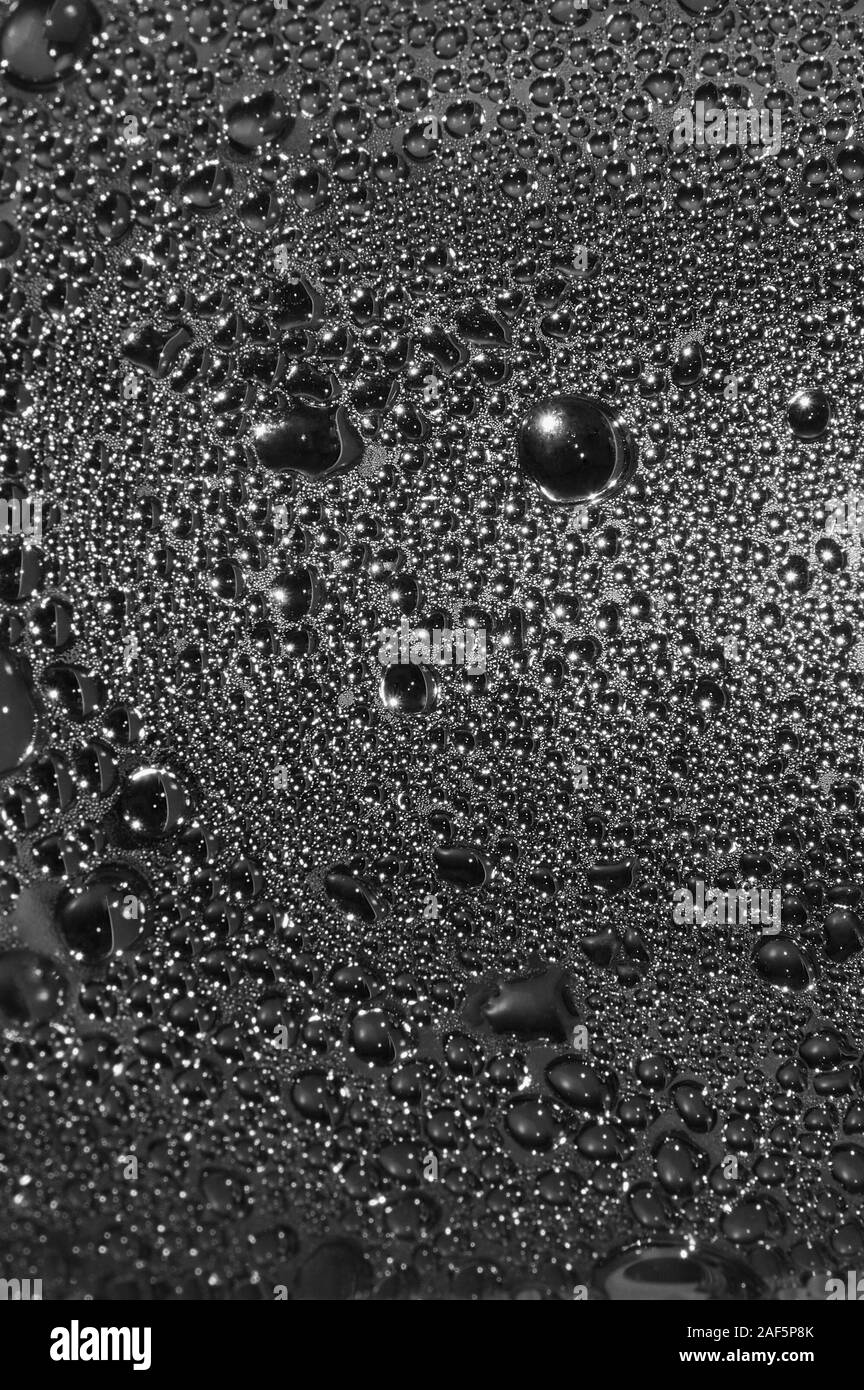 Natürliche Dunkelheit silbrig schwarzes Wasser Tautropfen Textur Makro Hintergrund, vertikal strukturierten nass Dampfblase Spritzer pattern copy Space, silber glänzend Stockfoto