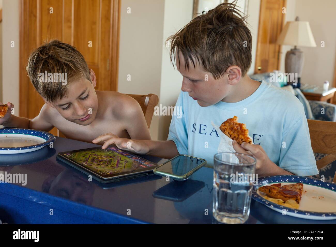 Elf und zwölf Jahre alten Jungen Video Spiel während der Mittagspause. Avon, Outer Banks, North Carolina. (Model Released) Stockfoto