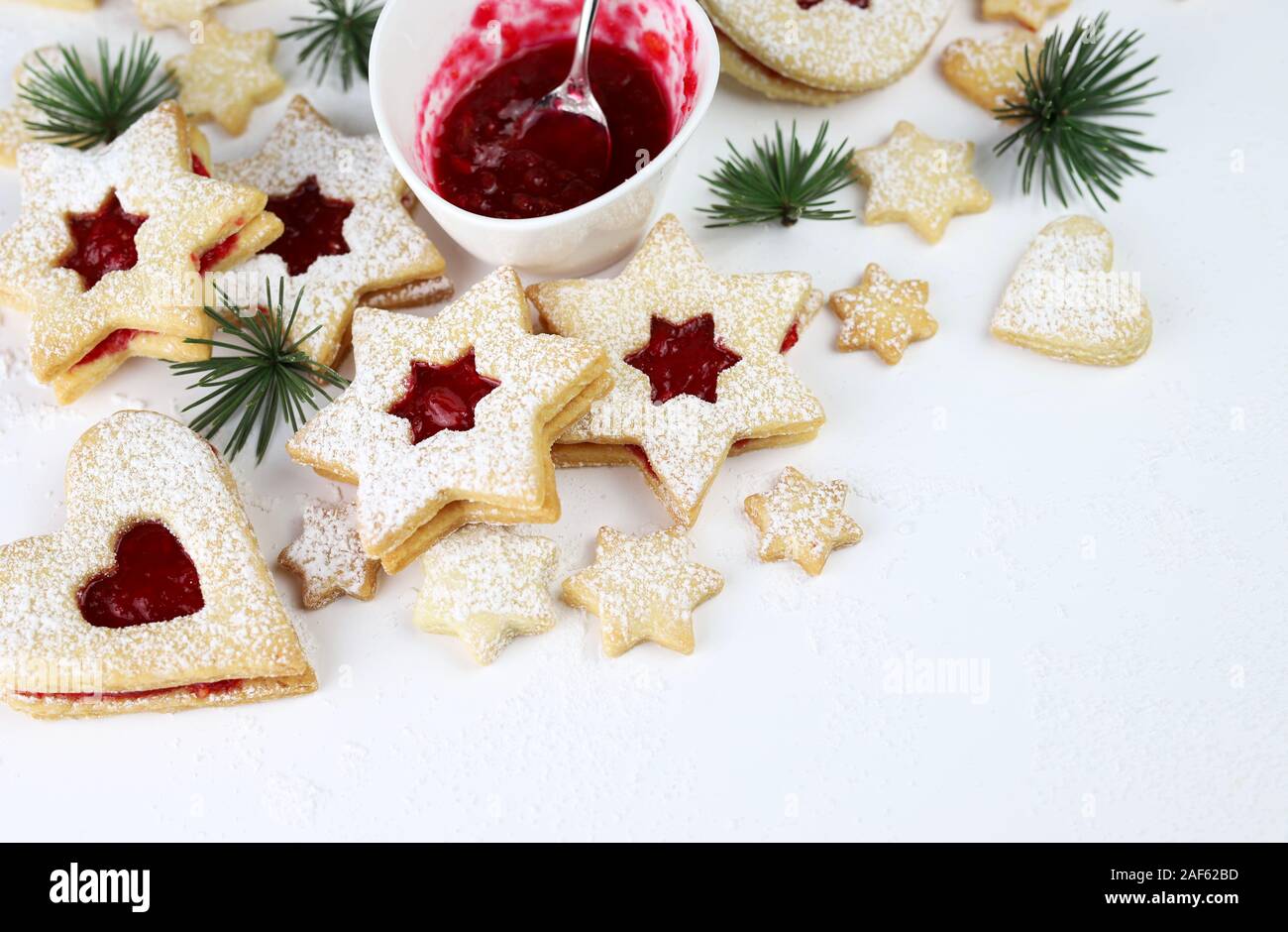 Linzer Weihnachtsplätzchen. Kekse mit mürbeteig ausrollen und Himbeermarmelade auf weißem Hintergrund. Stockfoto