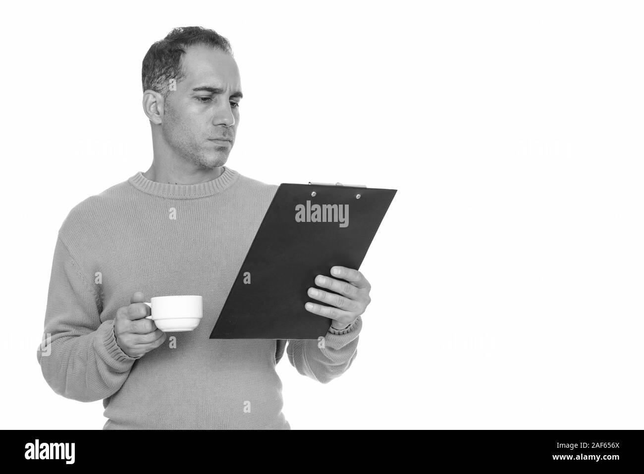 Reifen schönen persischen Mann lesen Zwischenablage während Sie Kaffee Tasse Stockfoto