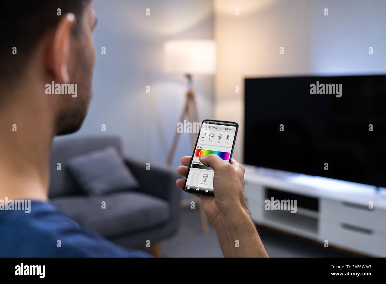 Nahaufnahme einer menschlichen Hand Einstellen elektrisches Licht durch Handy zu Hause Stockfoto