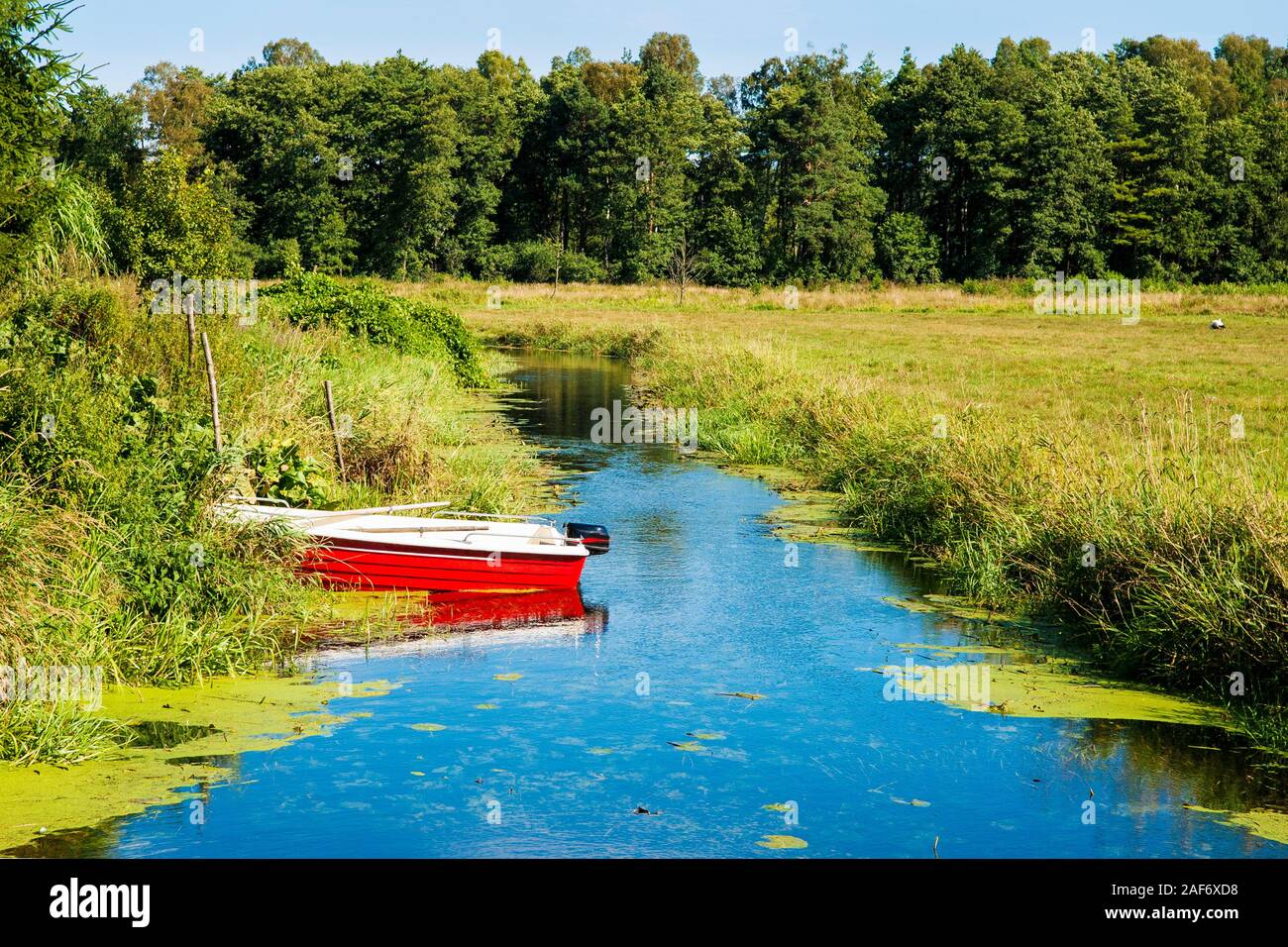 Sommer Landschaft der polnischen Ferienhaus mit Boot auf langsamen Fluss. Stockfoto