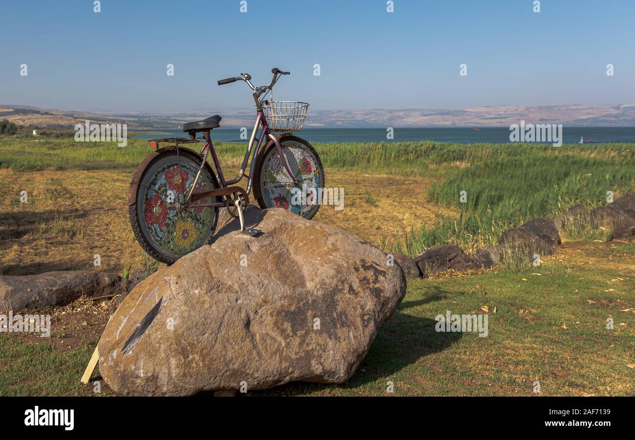 Blick auf den See Genezareth und die Berge am Horizont, vor einem Zyklus auf einem Felsen Stockfoto
