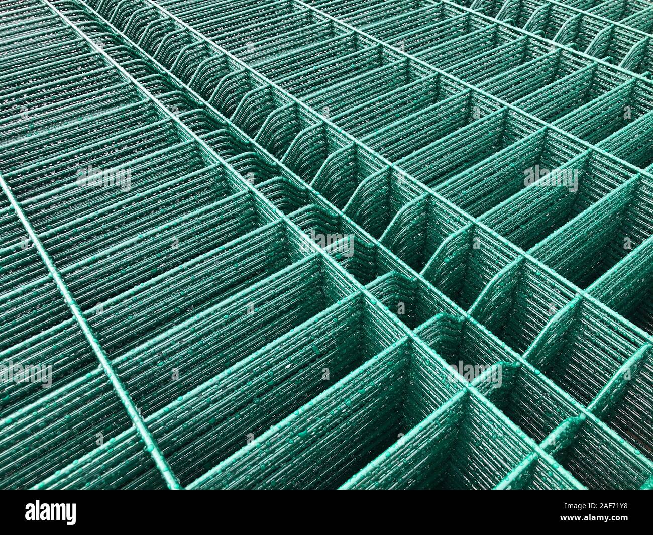 Regen fällt auf grün gefärbten Metallgitter. Stockfoto