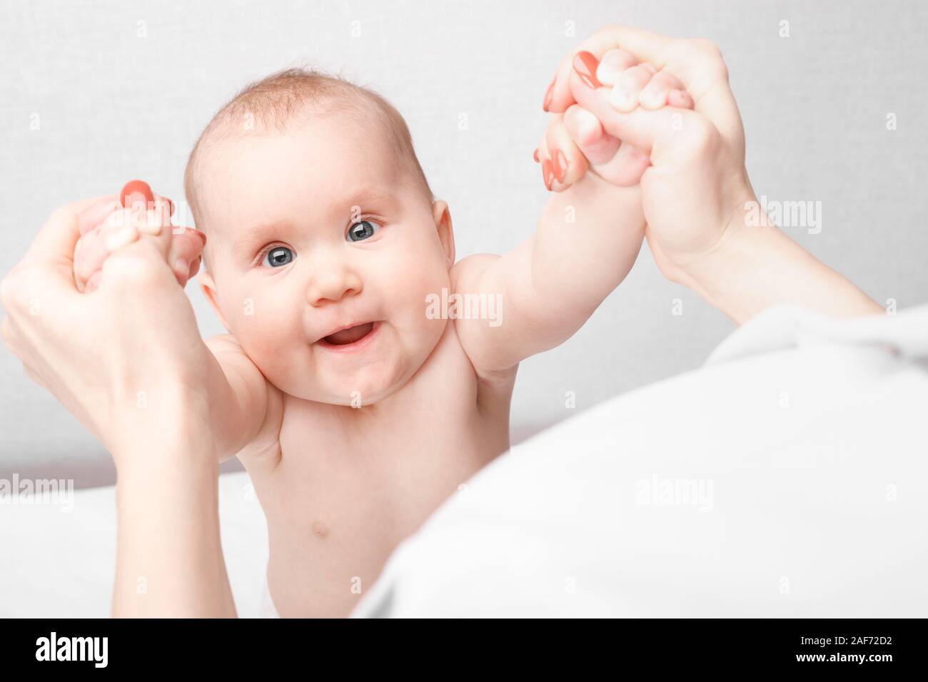 Gerne sechs Monate Baby Mädchen empfangen Massage Therapie in der pädiatrischen Klinik. Manuelle Therapeut manipuliert die chils Arme Stockfoto