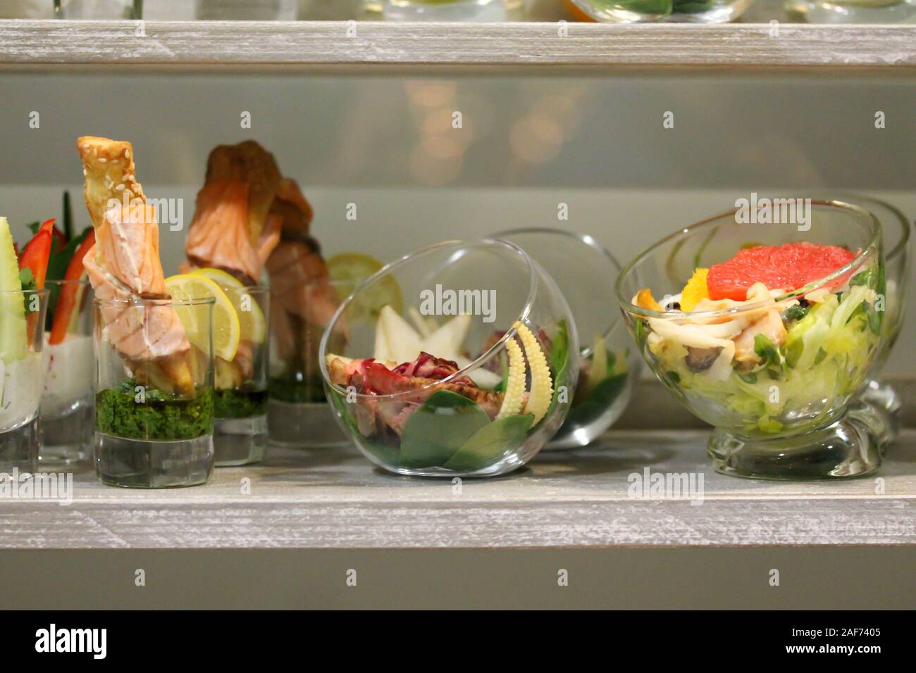 Snacks an der Stand-up-Party oder Buffet Lunch. Meeresfrüchte, Gemüse, Obst in Schalen und Gläser. Leckeres Essen Leckereien auf dem Tisch. Catering Service. Stockfoto