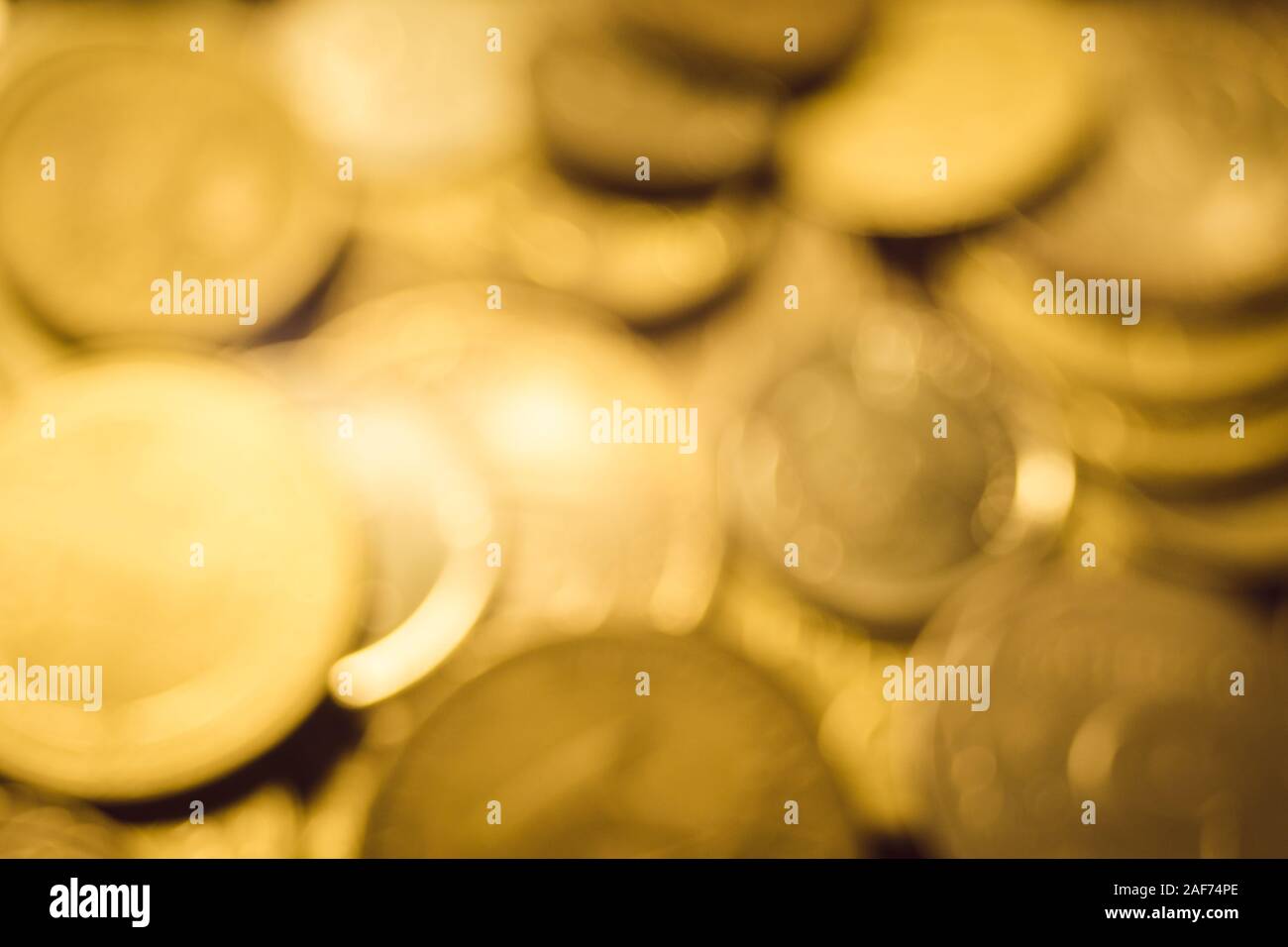 Hintergrund goldene Haufen verschiedener Goldmünzen auf dem Tisch, verschwommene unscharfe Foto Stockfoto