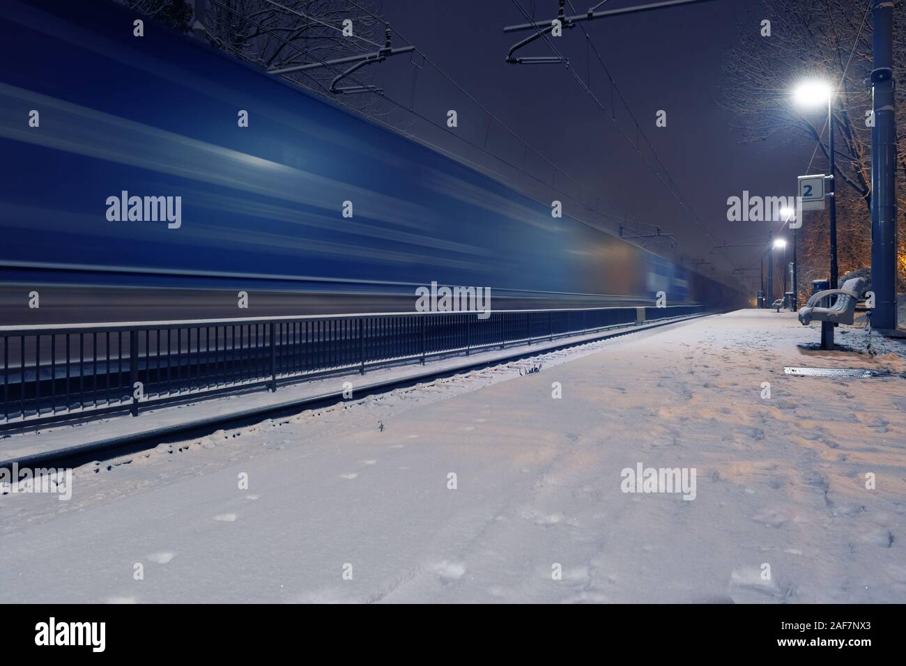 Vorbeifahrenden Güterzug in verschwommene Bewegung am Bahnhof in einer Winternacht. Transport und Logistic Service Konzepte Stockfoto