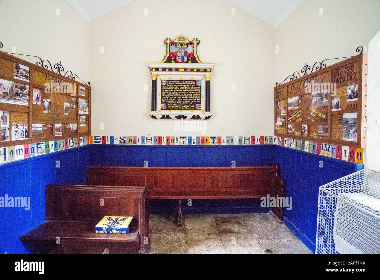Einige der erhaltenen Kirchenbänke und Bilder des dörflichen Lebens in der Pfarrkirche in das verlassene Dorf Tyneham, Dorset, England, Großbritannien Stockfoto