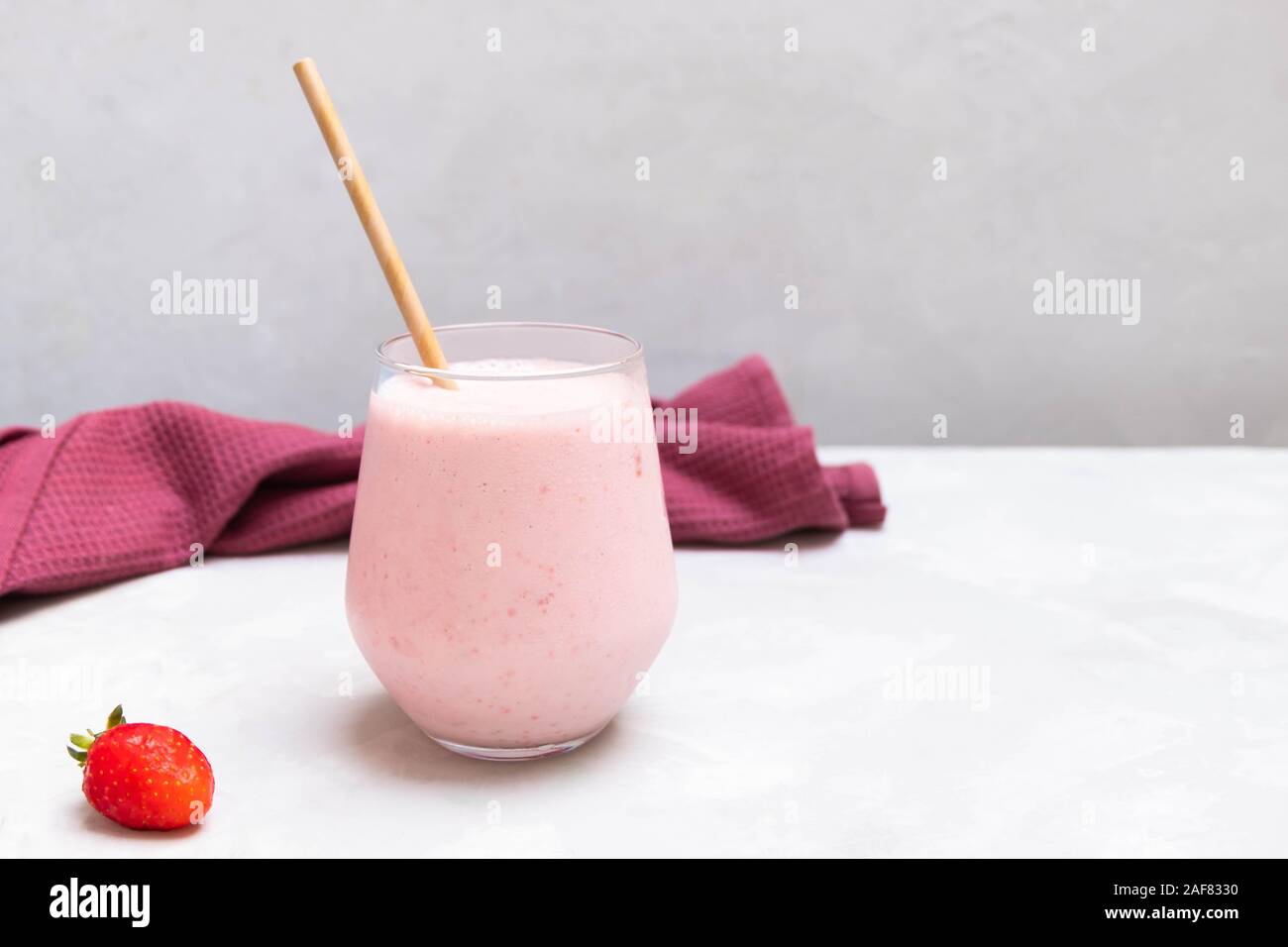 Traditionelle indische Joghurt Drink Erdbeer Lassi in einem Glas Schale auf konkrete neutralen Hintergrund, kopieren Raum Stockfoto