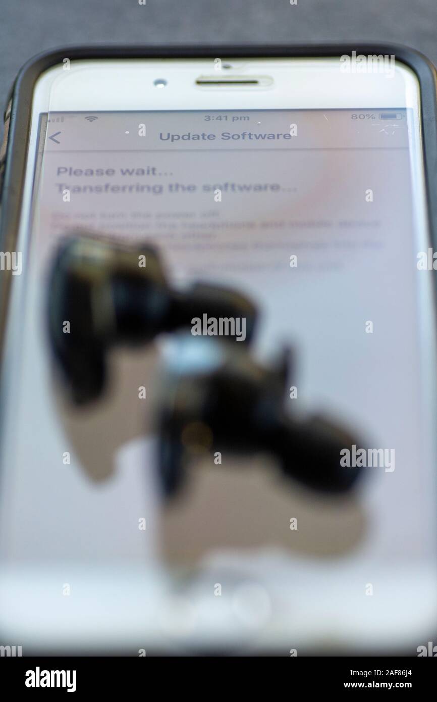 Drahtlose Ohrhörer werden über das Mobilteil aktualisiert Stockfoto