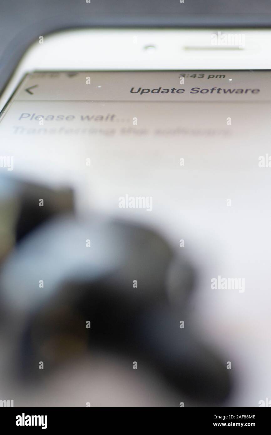 Drahtlose Ohrhörer werden über das Mobilteil aktualisiert Stockfoto