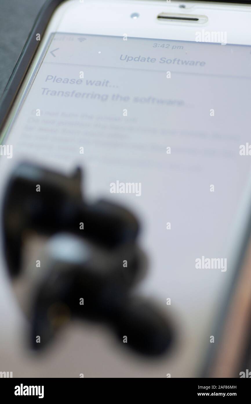 Drahtlose Ohrhörer werden über das Mobilteil aktualisiert Stockfoto
