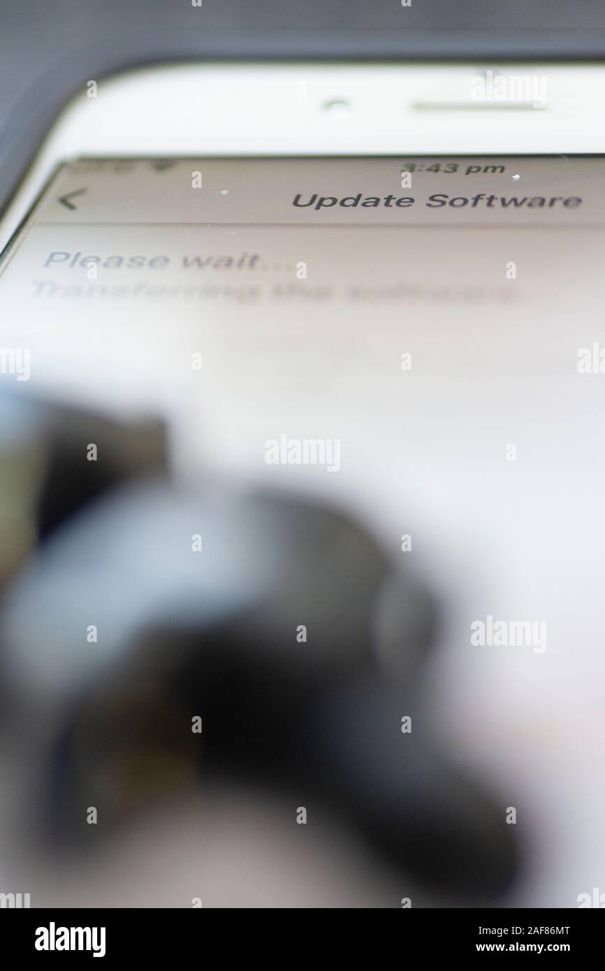 Drahtlose Ohrhörer werden über das Mobilteil aktualisiert Stockfoto