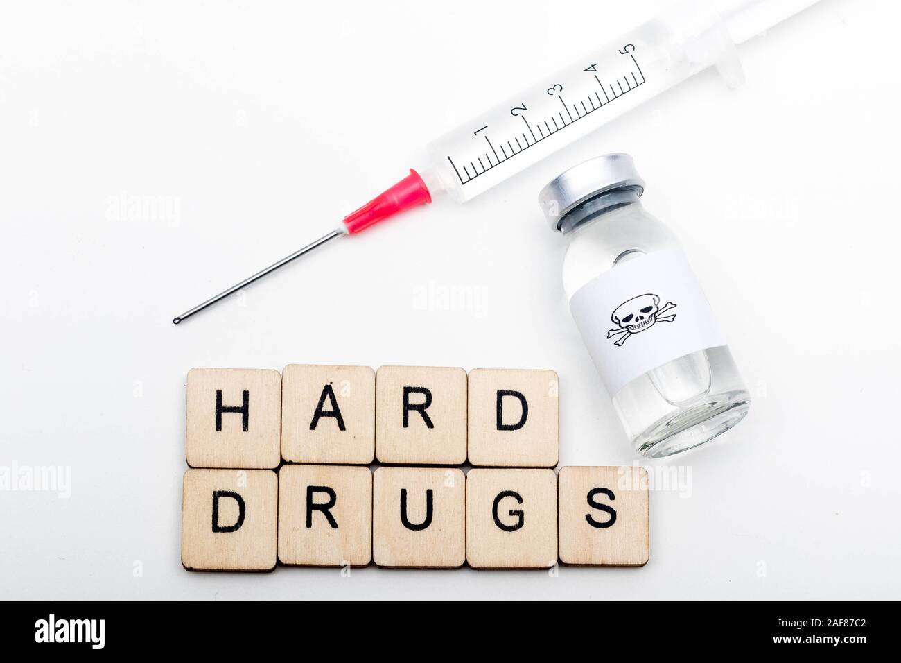 Ein Glas medizinische Durchstechflasche mit einem Totenkopf auf weißem Hintergrund mit einem Schild harte Drogen mit einer Spritze Stockfoto