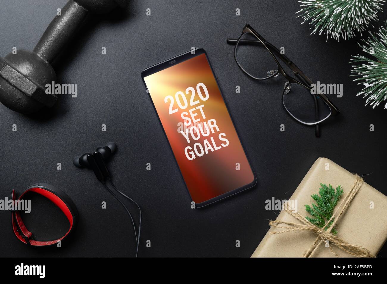 2020 Vorsätze im Neuen Jahr fitness gesund Ziele Konzept. 2020 IHRE ZIELE Text auf Mobiltelefon auf Schwarzer Tisch mit Kurzhanteln, smart Watch, Gi Stockfoto
